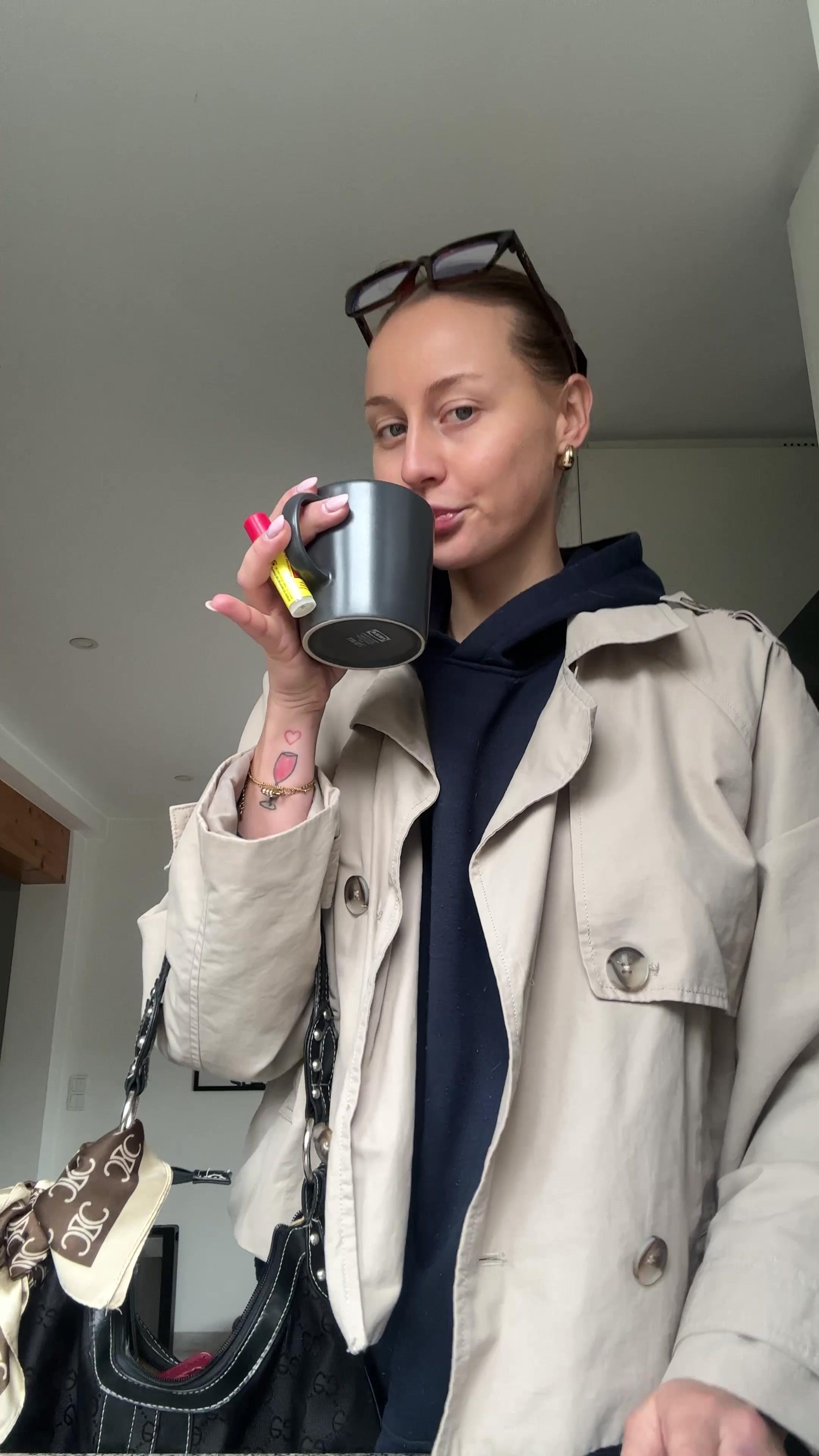 Woman in Trench Coat Drinking Coffee