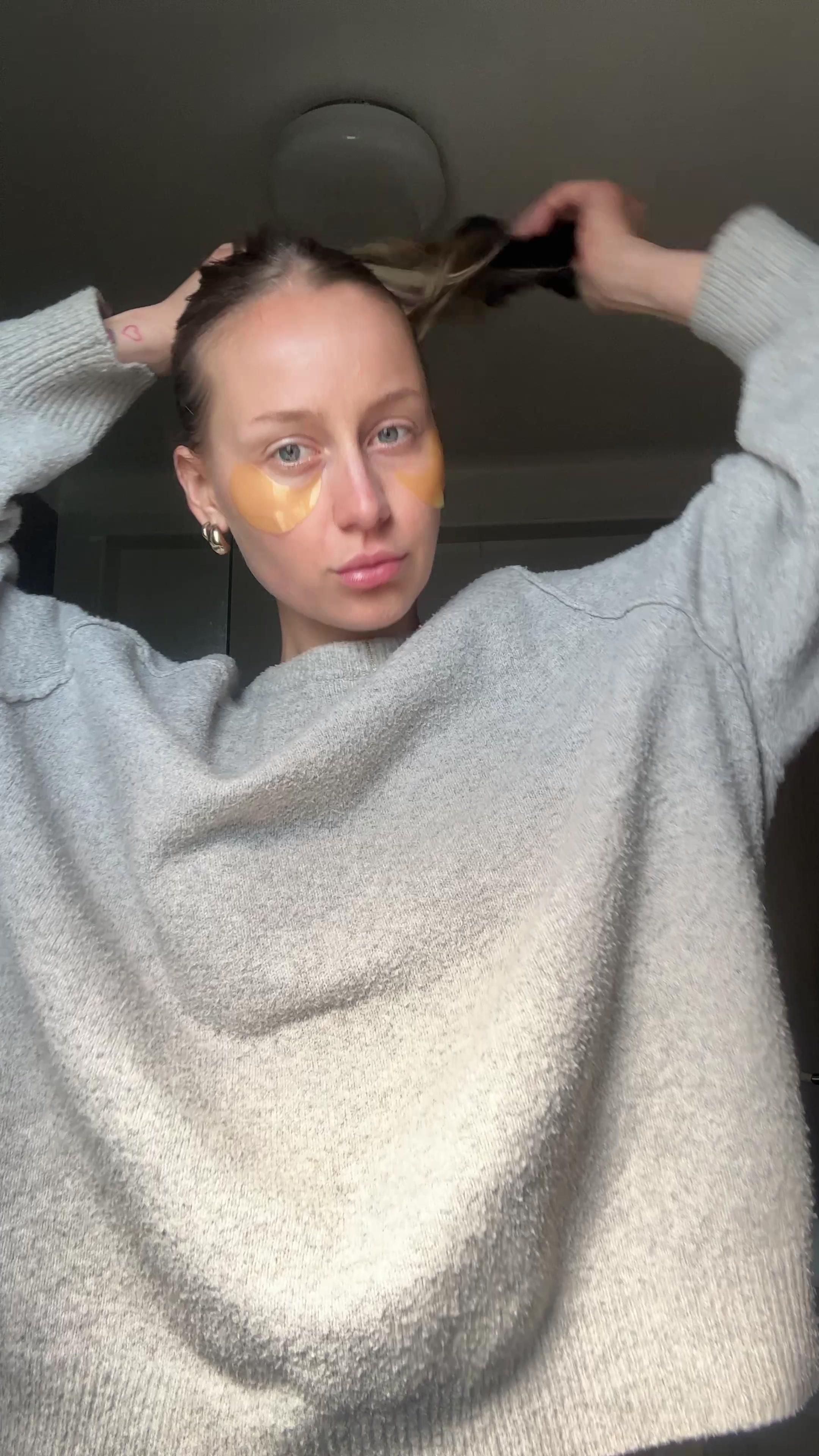 Woman Putting Hair Up Wearing Eye Patches